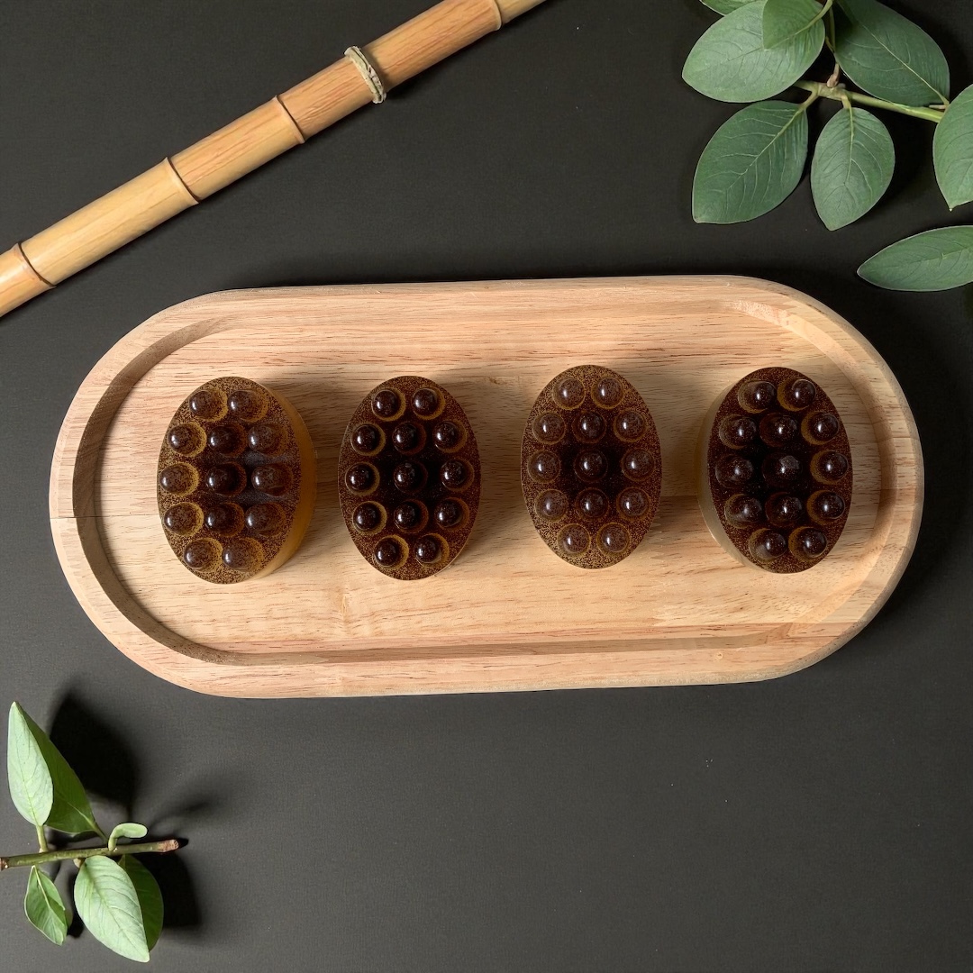 Savons de massage exfoliants ovales Auréa des Sens sur plateau en bois, avec picots de massage